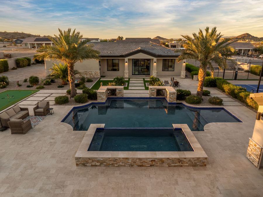 Aerial twilight view of the pool, raised spa and palms toward the pool house