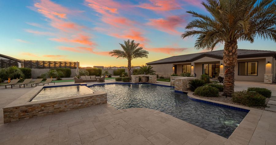 Raised spa and pool edge on the travertine deck at sunset
