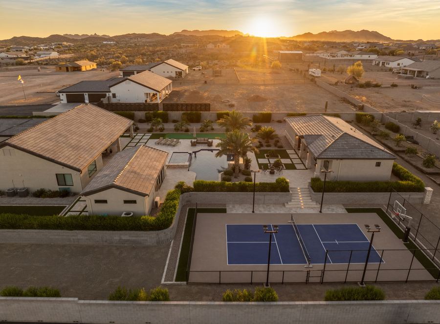 Aerial sunset view over the backyard, pickleball court and mountains