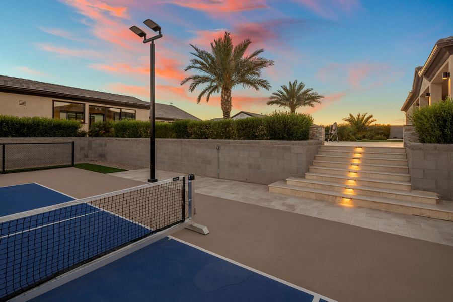Pickleball net and lit steps up to the yard at sunset
