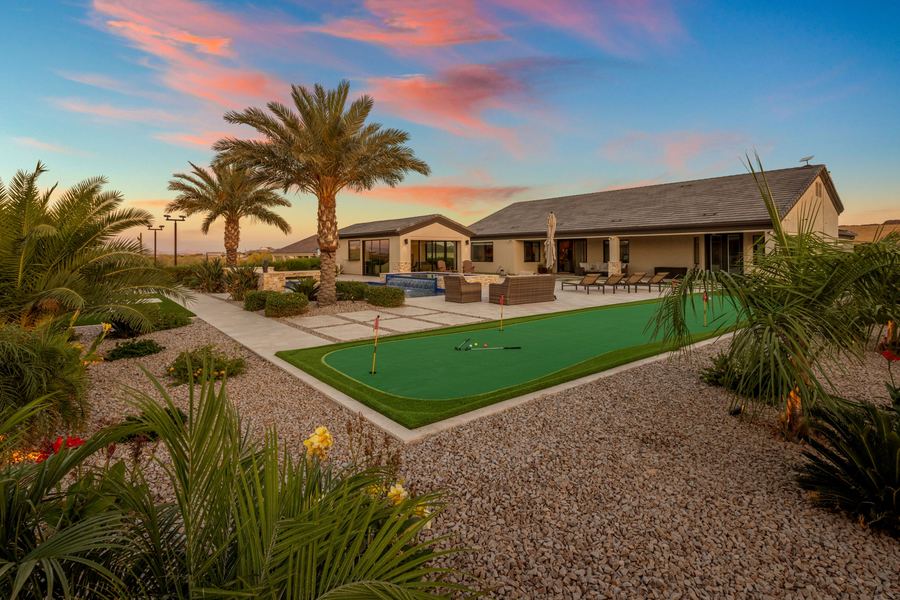 Putting green and lounge deck stretching to the main house at sunset