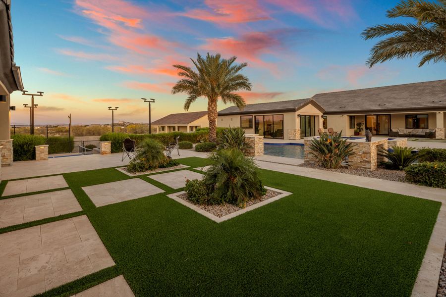 Turf and travertine grid with a raised planter at sunset