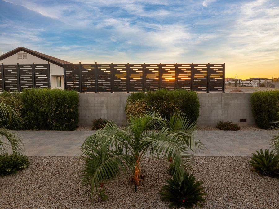 Palm and shrubs below the slatted privacy screen at sunset