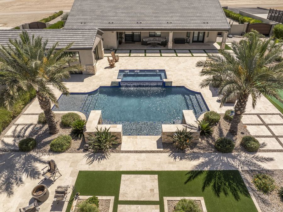 Elevated view of the pool and raised spa framed by palms