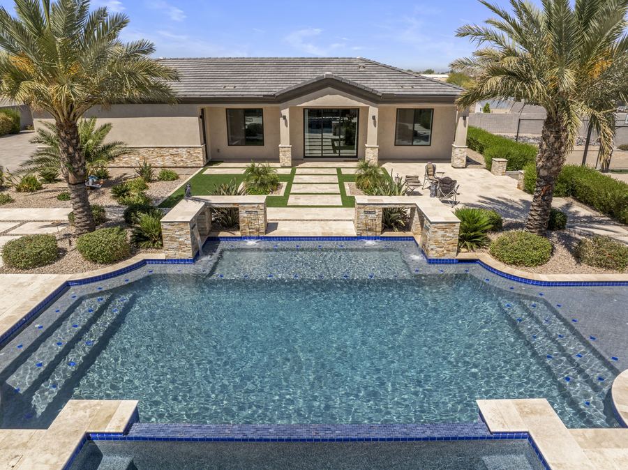 Pool and stone water feature pillars facing the pool house