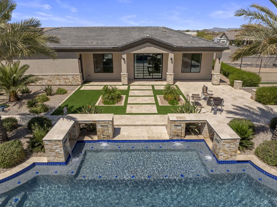 Aerial view over the pool to the turf and paver courtyard and pool house