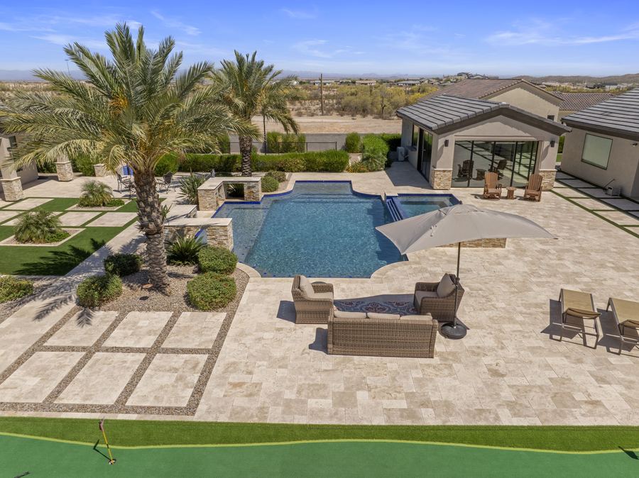 Aerial view of the pool, lounge seating and pool house by the putting green