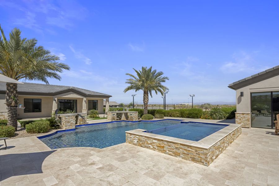 Pool with raised stone spa toward the pool house