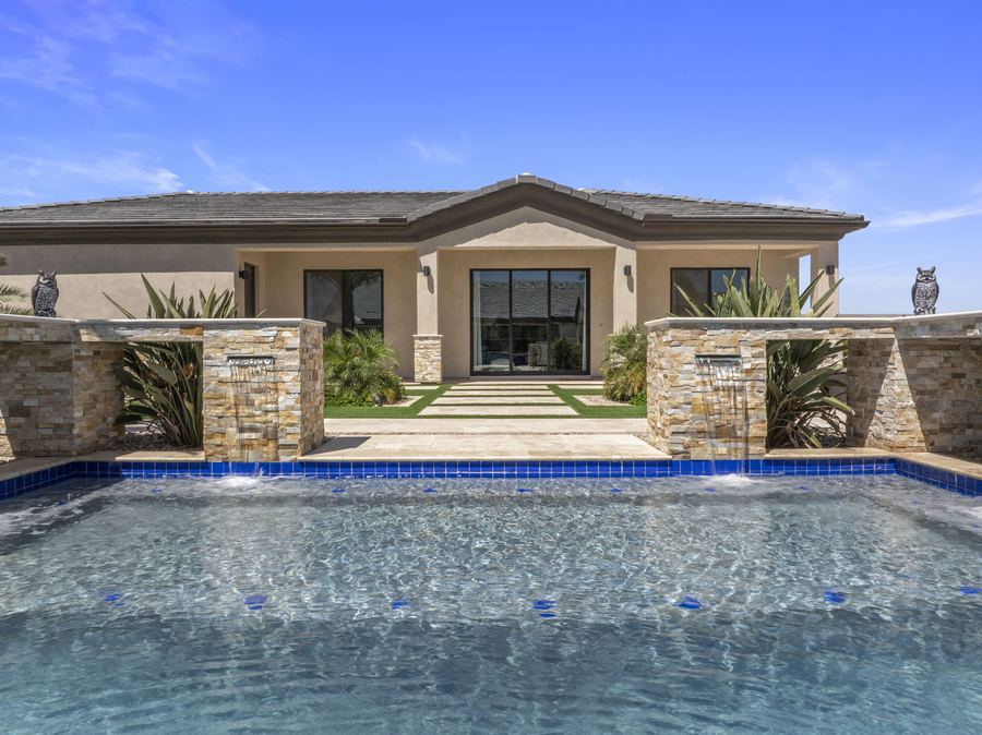 Stacked stone pillars with water spouts facing the pool house