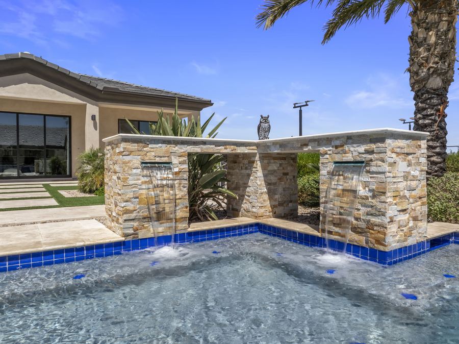 Stacked stone water feature walls at the pool edge
