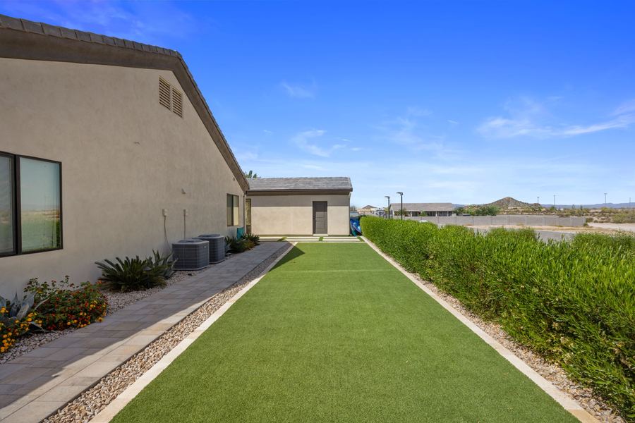 Turf strip running along the side yard between hedge and house