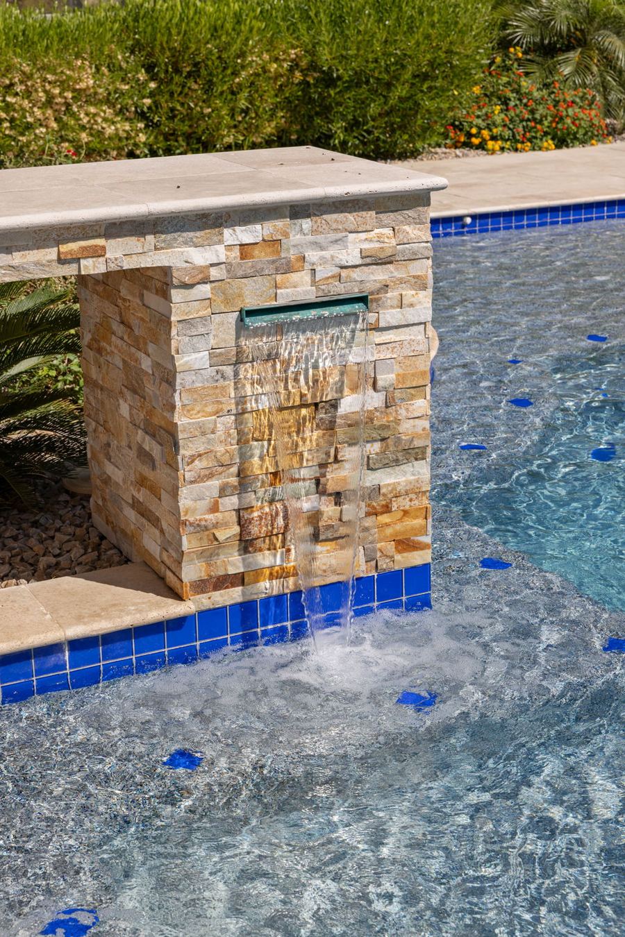 Stone scupper pouring into the pool