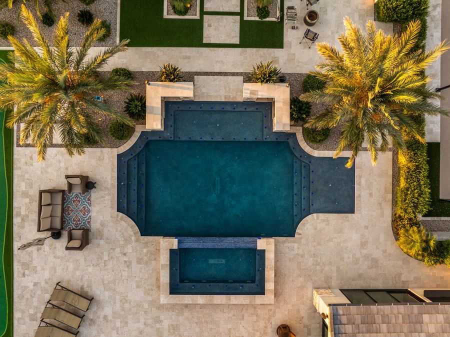 Top-down twilight view of the pool, raised spa and palms