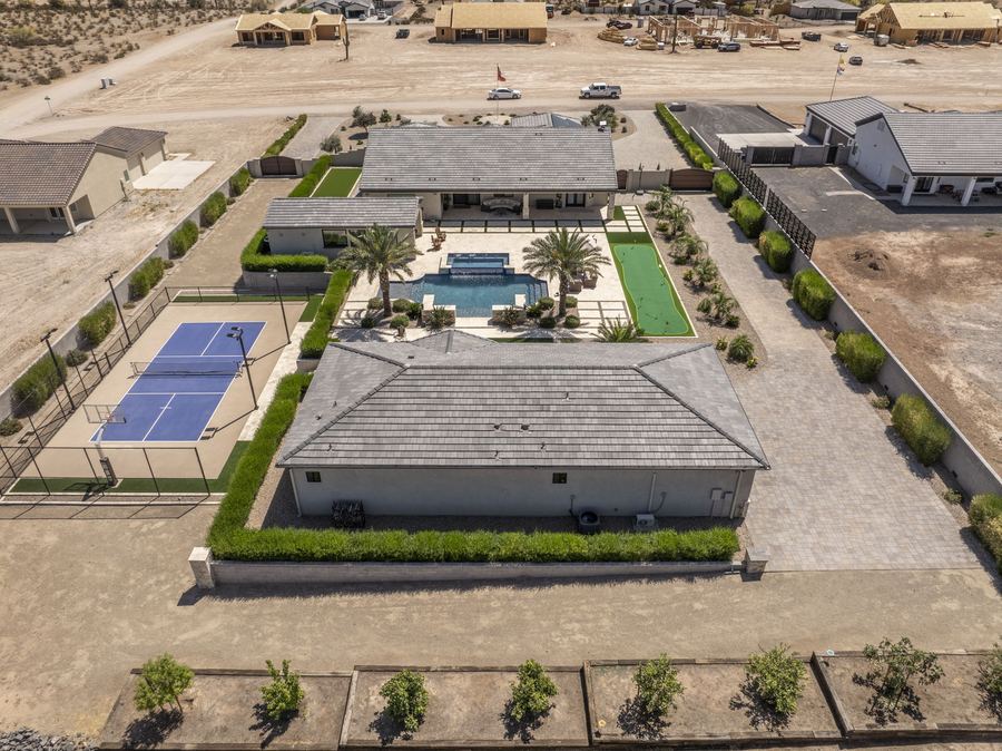 Aerial view of the backyard, court and pool house from the rear