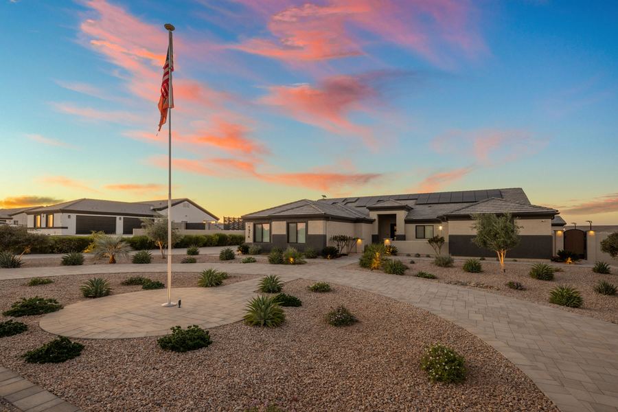 Front yard with flagpole circle and desert plantings at sunset