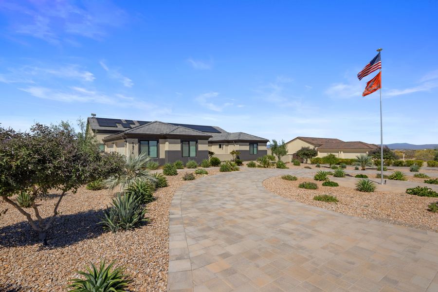 Paver drive through desert plantings toward the house