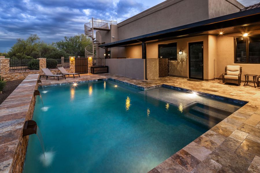 Pool and covered patio at blue hour with lights on