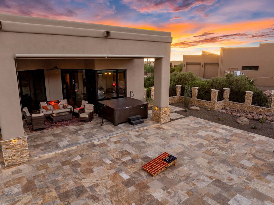 Covered seating area and travertine patio at sunset