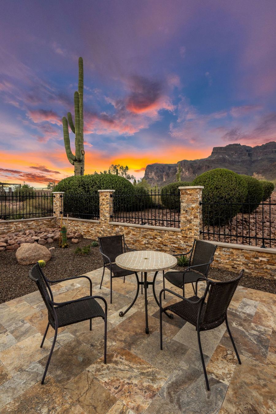 Bistro table on travertine beside a saguaro at sunset
