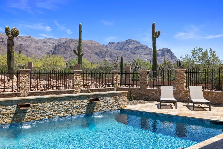 Sheer water features spilling into the pool with lounge chairs above