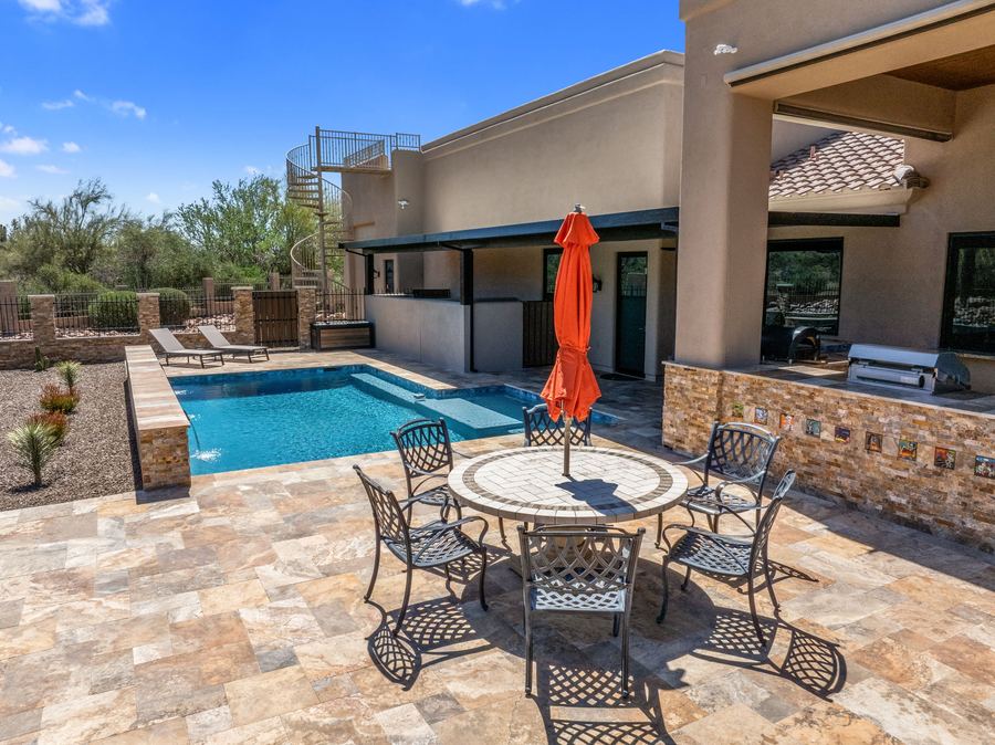 Dining set and pool beside the outdoor kitchen by day