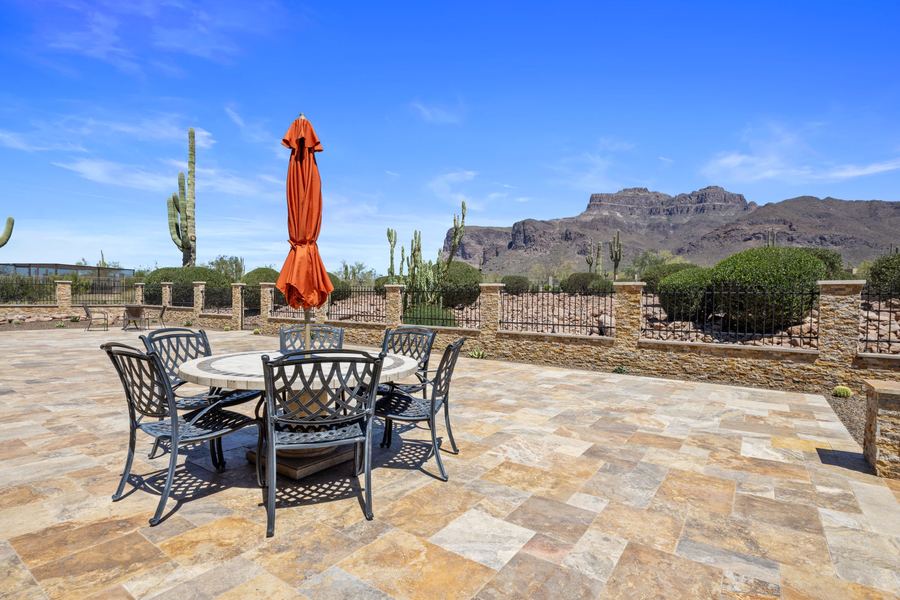 Dining set with orange umbrella on travertine with mountain view