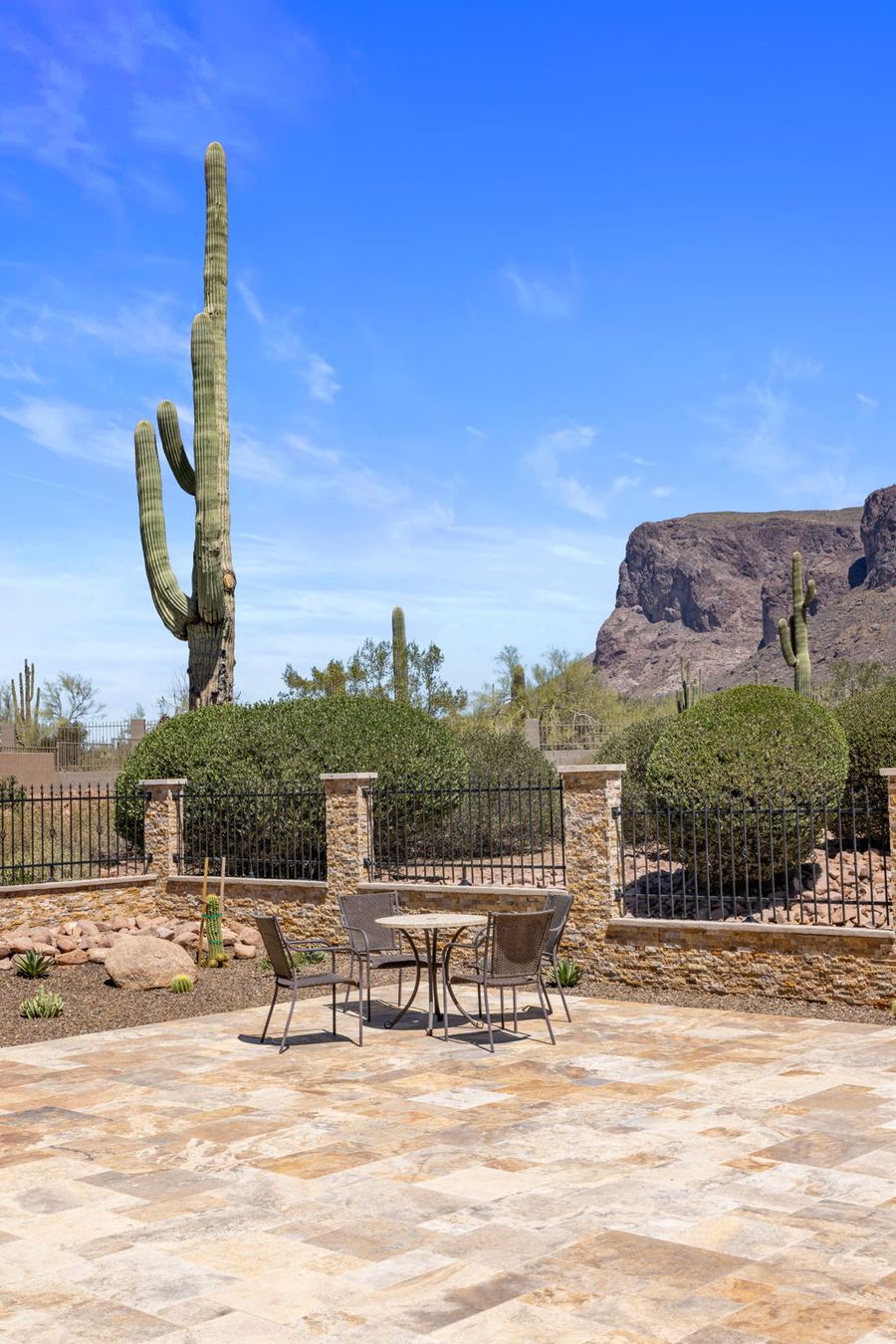 Bistro set on travertine with saguaro and mountain beyond