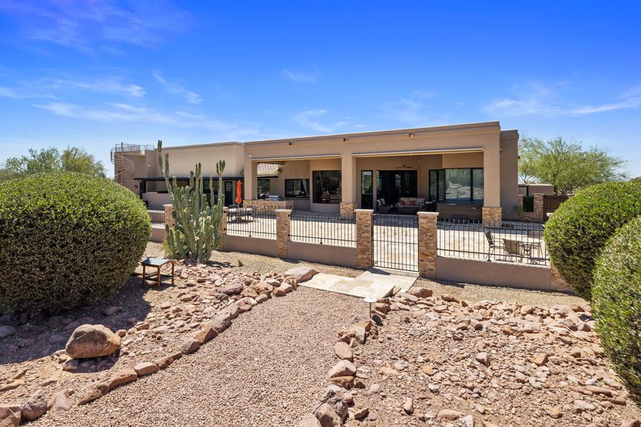 Gravel path between desert shrubs leading to the house