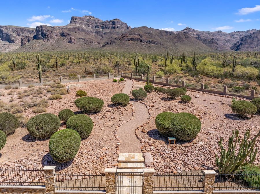 Aerial of desert yard with paths and round shrubs toward the mountains