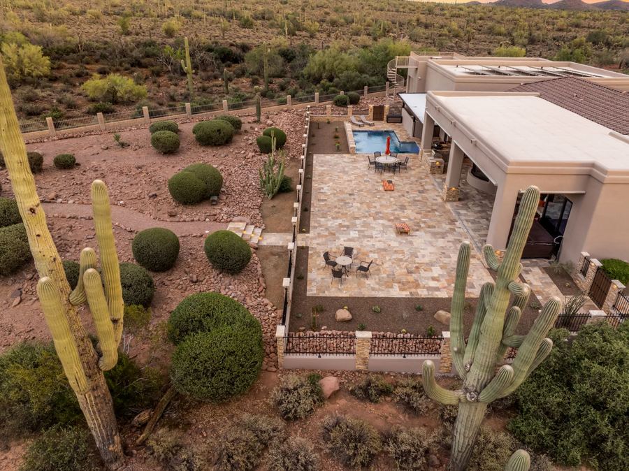 Aerial of the patio and pool framed by saguaros at dusk