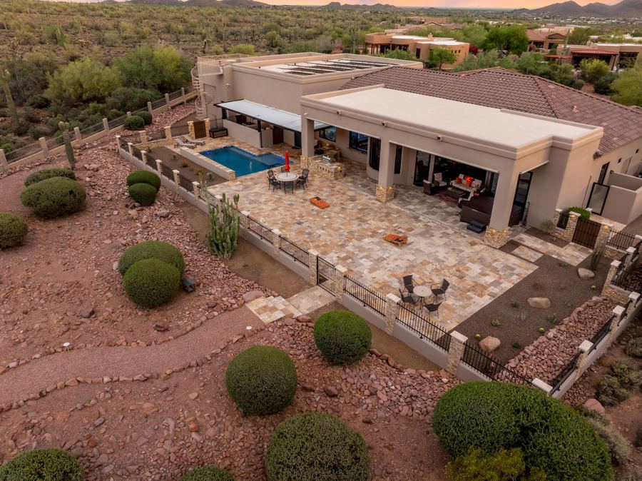 Aerial of the covered patio, pool and travertine deck at dusk