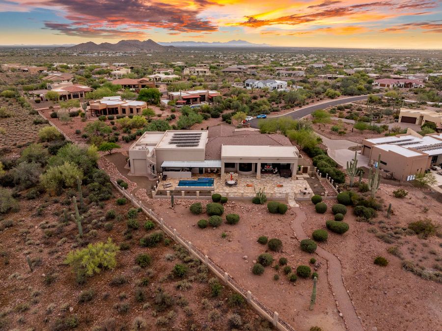 Aerial of the home, pool and desert lot at sunset