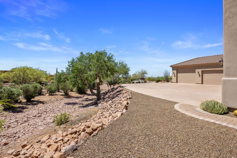 Gravel and rock landscaping along the front drive