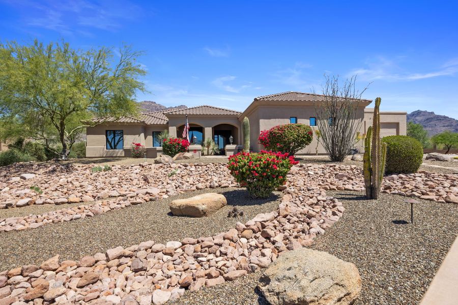 Front yard with desert plants, boulders and flowering shrubs