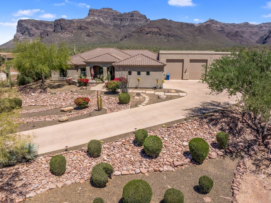 Desert front yard with round shrubs along the curved driveway