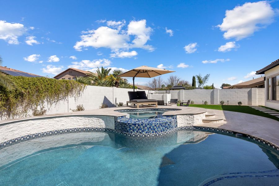 Raised tiled spa spilling into the pool on a sunny day