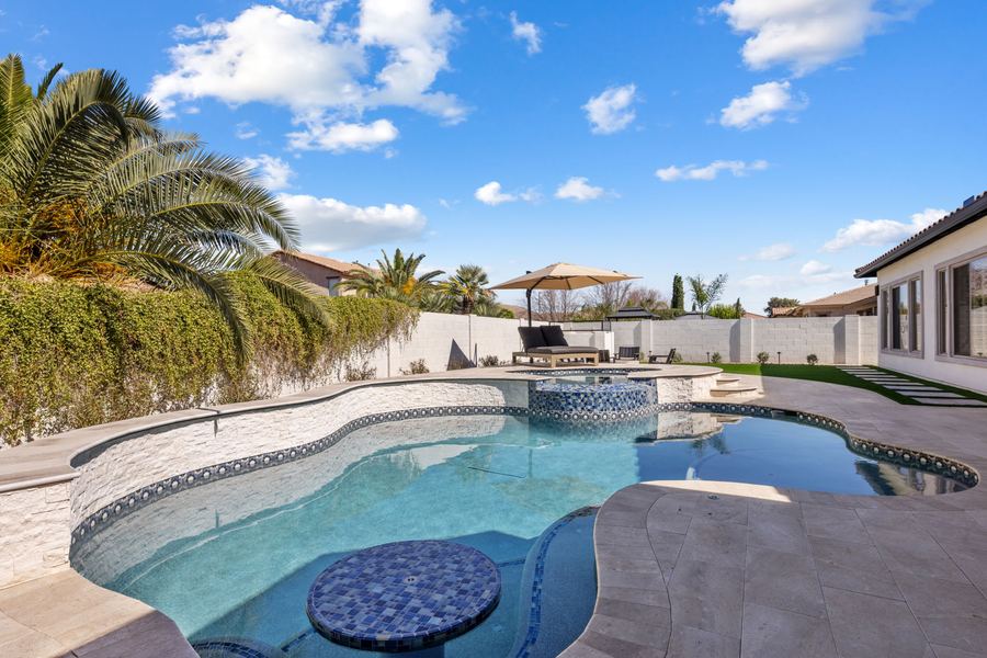 Freeform pool with tiled table and raised spa in daylight