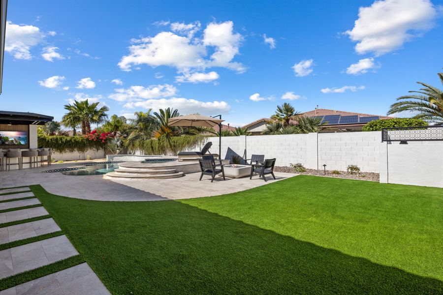 Turf lawn and stepping pavers leading to the pool area