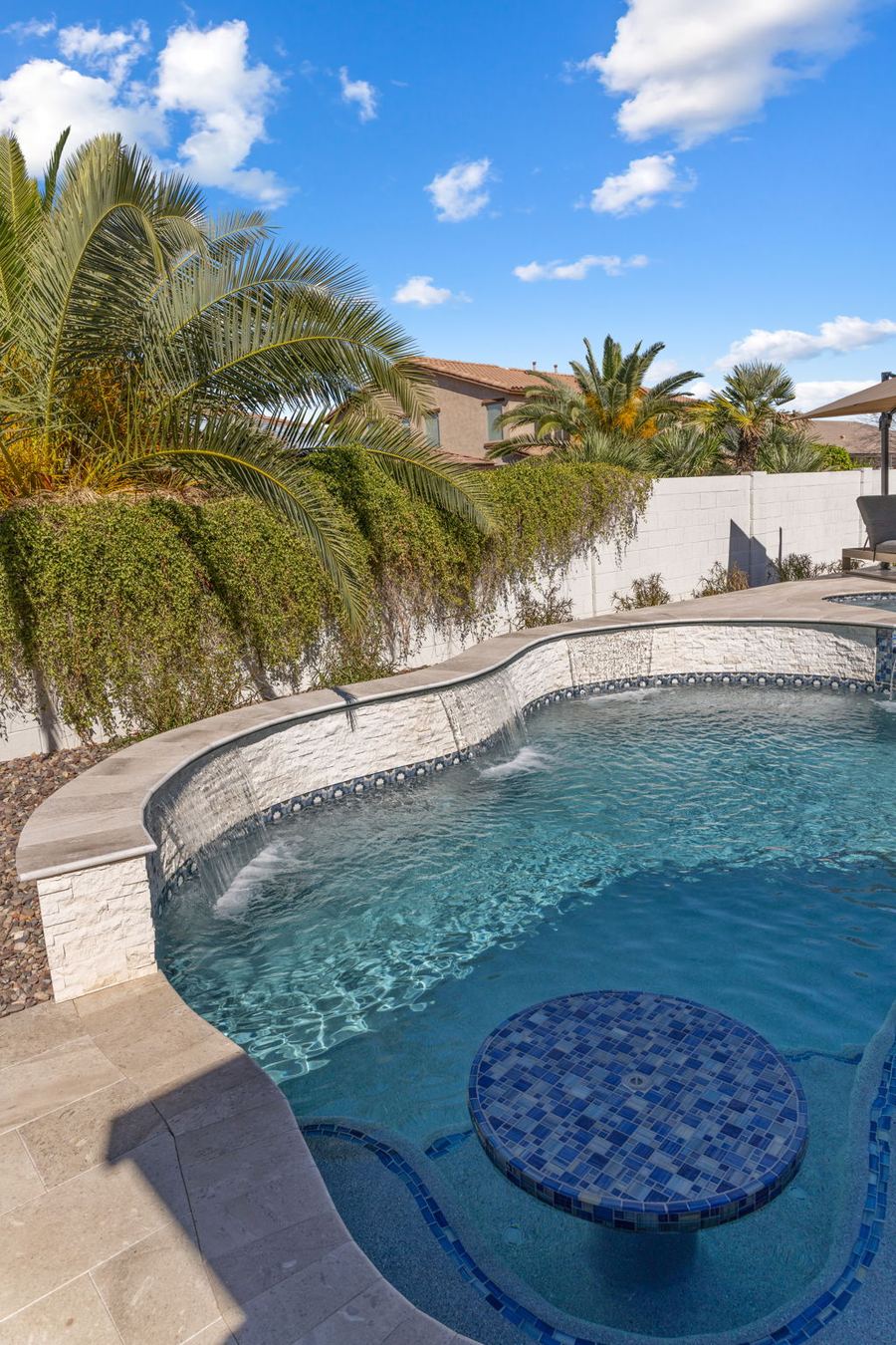 Tiled table in the pool lagoon with palms overhead
