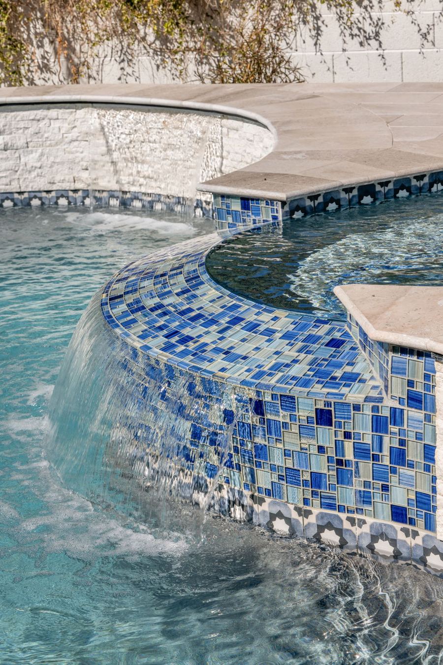Curved mosaic tile spa edge with spillover