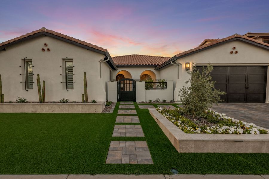 Front paver walkway through turf to the entry gate at twilight