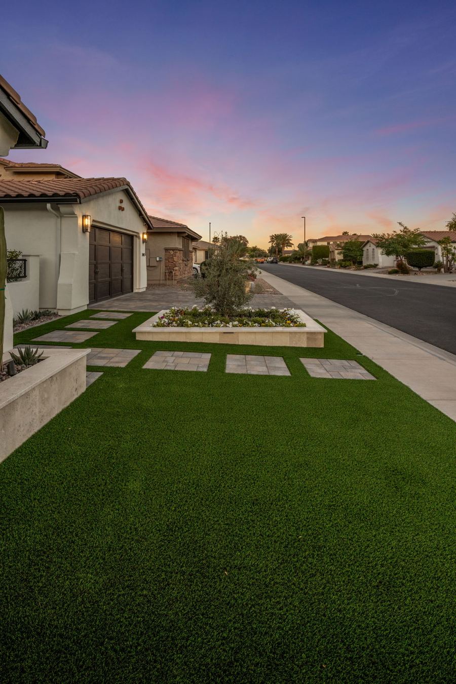 Front turf lawn with stepping pavers along the street at dusk