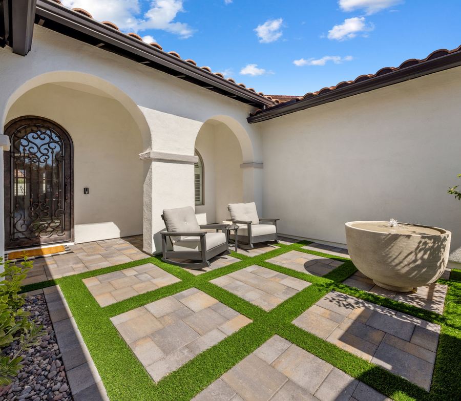 Front courtyard with paver grid, lounge chairs and fountain