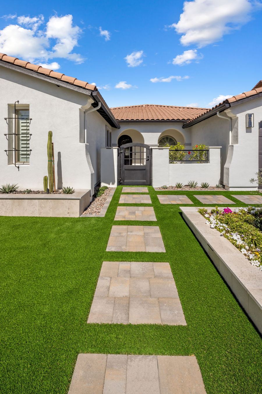 Paver walkway through turf leading to the front entry gate